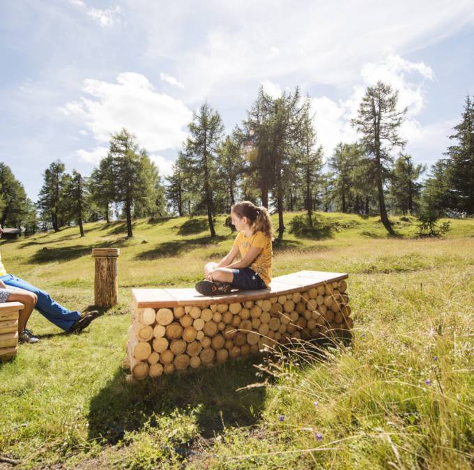 Personen entspannen auf Holzvorrichtungen im Feld